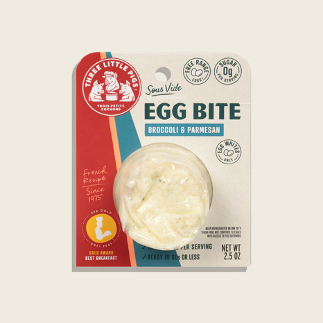 Three Little Pigs Egg Bite packaging with broccoli and parmesan flavor on a beige background