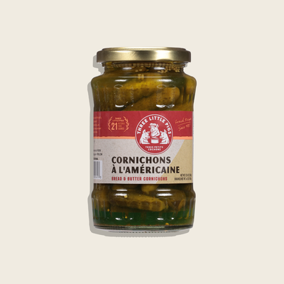 Jar of cornichons with a visible label on a light beige background