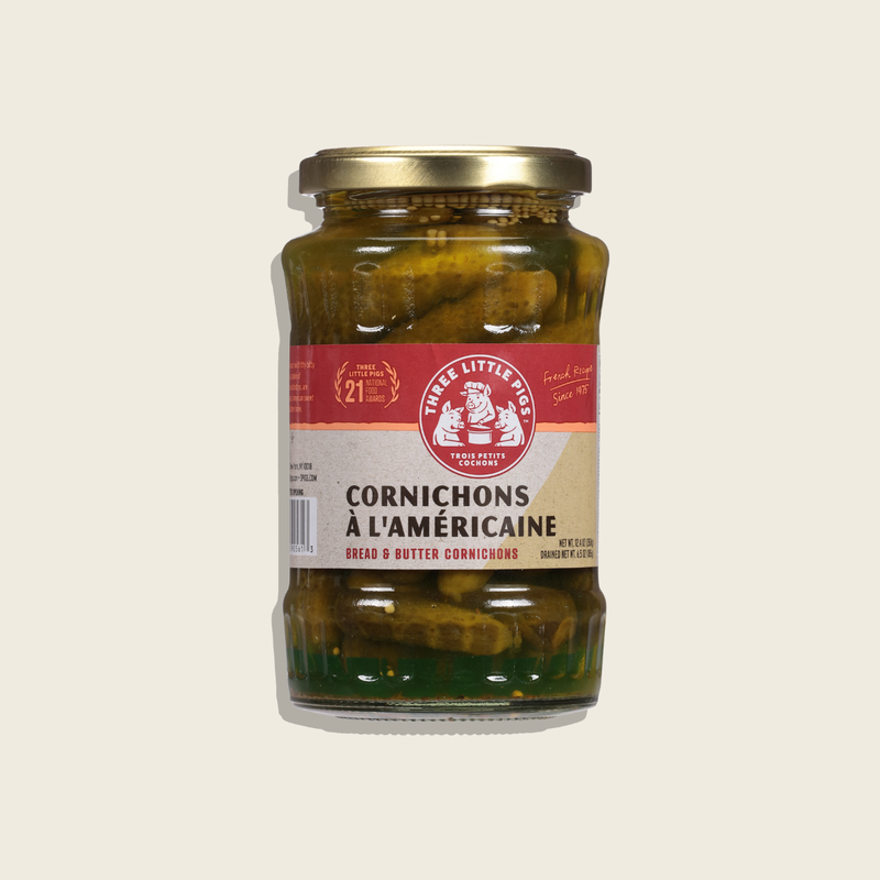 Jar of cornichons with a visible label on a light beige background