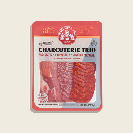 Packaged Charcuterie Trio with prosciutto, soppressata, and pepperoni on a beige background